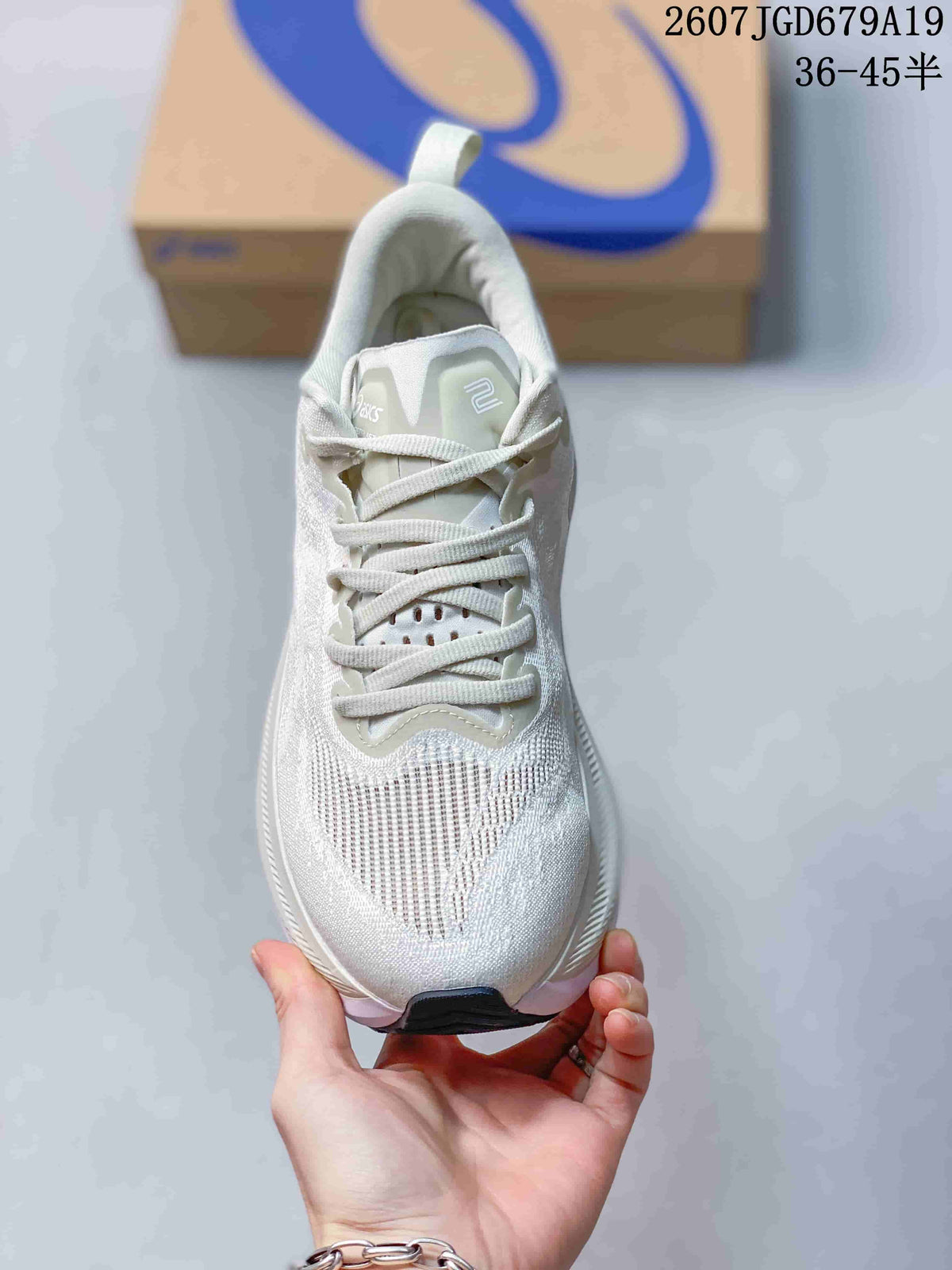 Top view of a white lace-up ASICS running sneaker showing the tongue, laces, ventilation area, and dark toe outsole section.