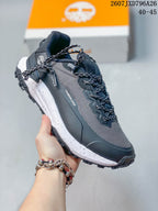Angled side view showing Timberland branding, patterned laces, dark upper panels, and rugged outsole.