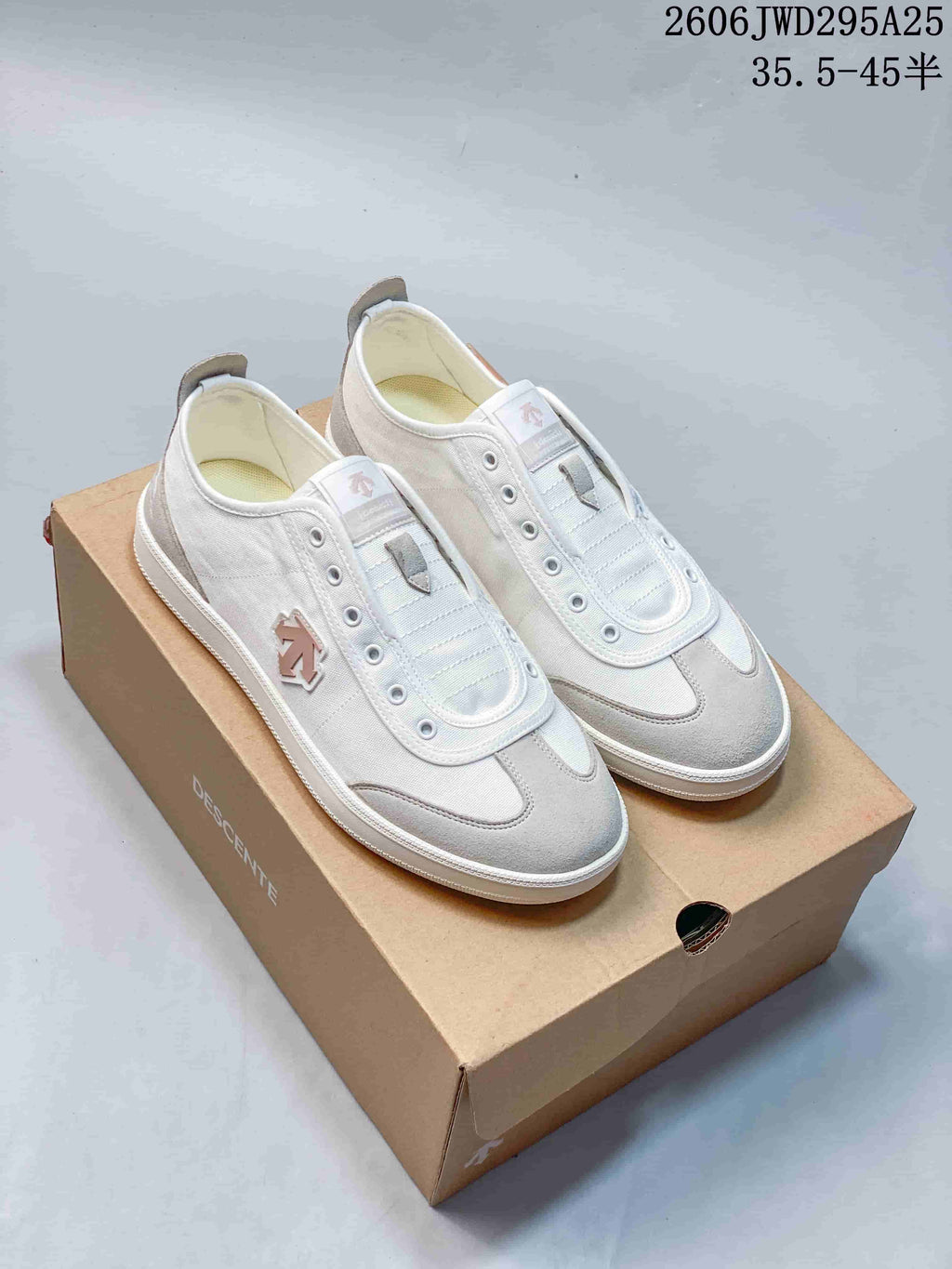 White and gray DESCENTE low-top sneakers displayed on a box
