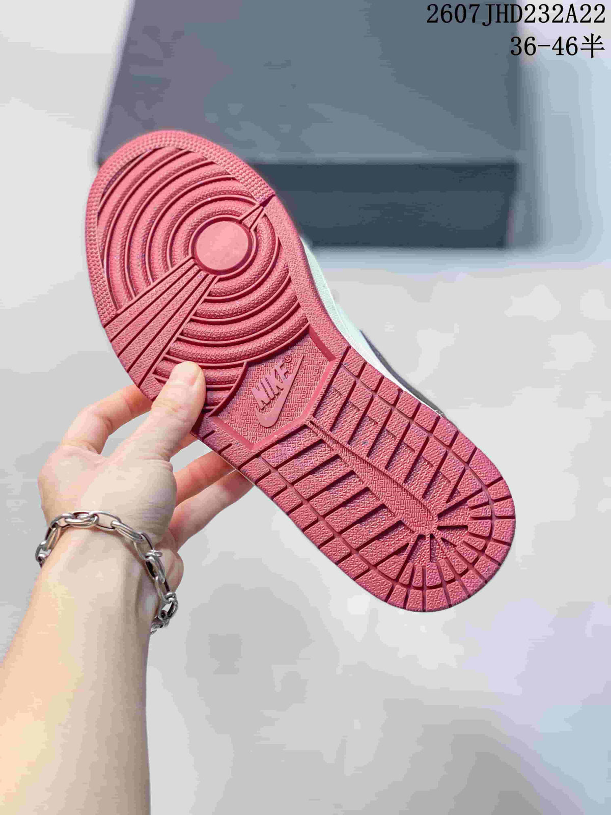 Close view of the red rubber outsole with circular traction and molded branding.