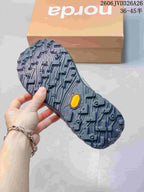 Close view of the shoe outsole with deep patterned tread and a small yellow insert.