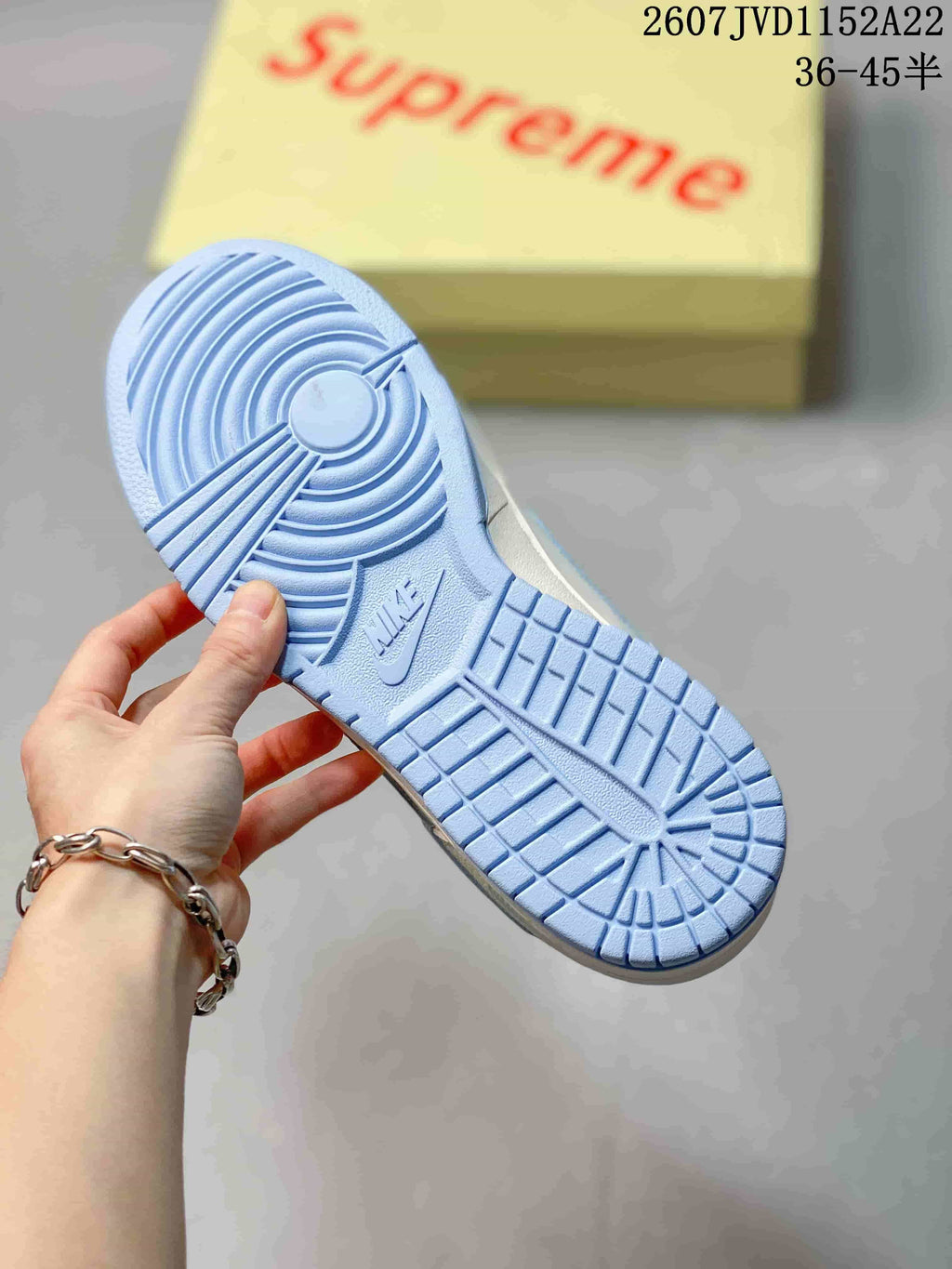 Underside of the sneaker showing the light blue rubber outsole and circular traction pattern.