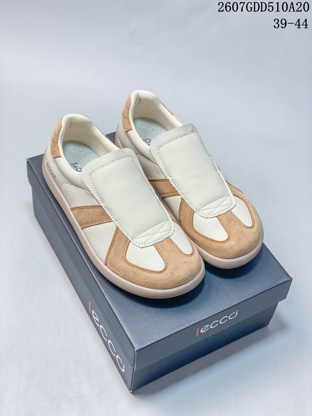 Pair of cream and tan ECCO sneakers displayed on a branded shoe box.