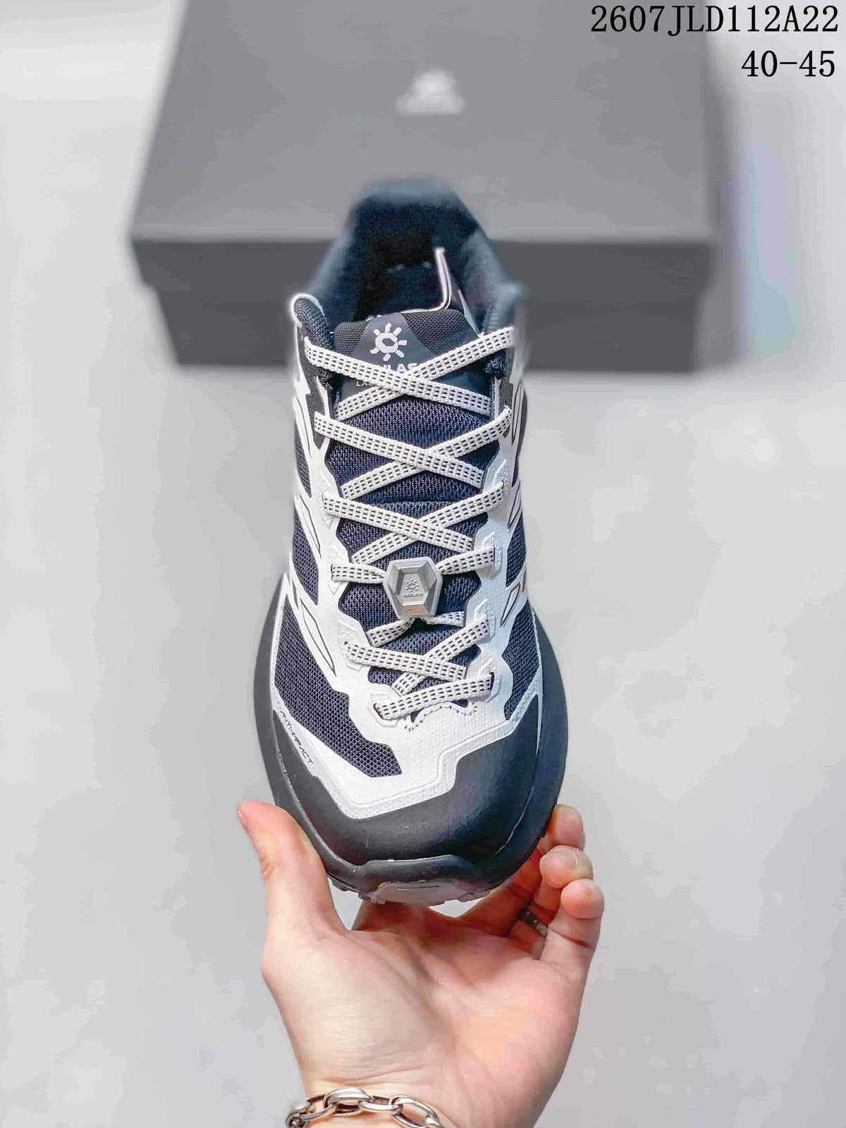 Front view showing the mesh toe box, white lace system, and central lace adjustment piece.