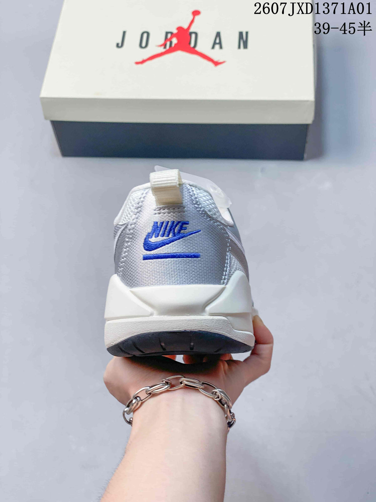 Rear view of a white and silver sneaker with blue heel branding.