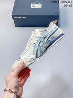 Side profile of the cream and pale blue low-top sneaker with layered side stripes and silver-look overlays.