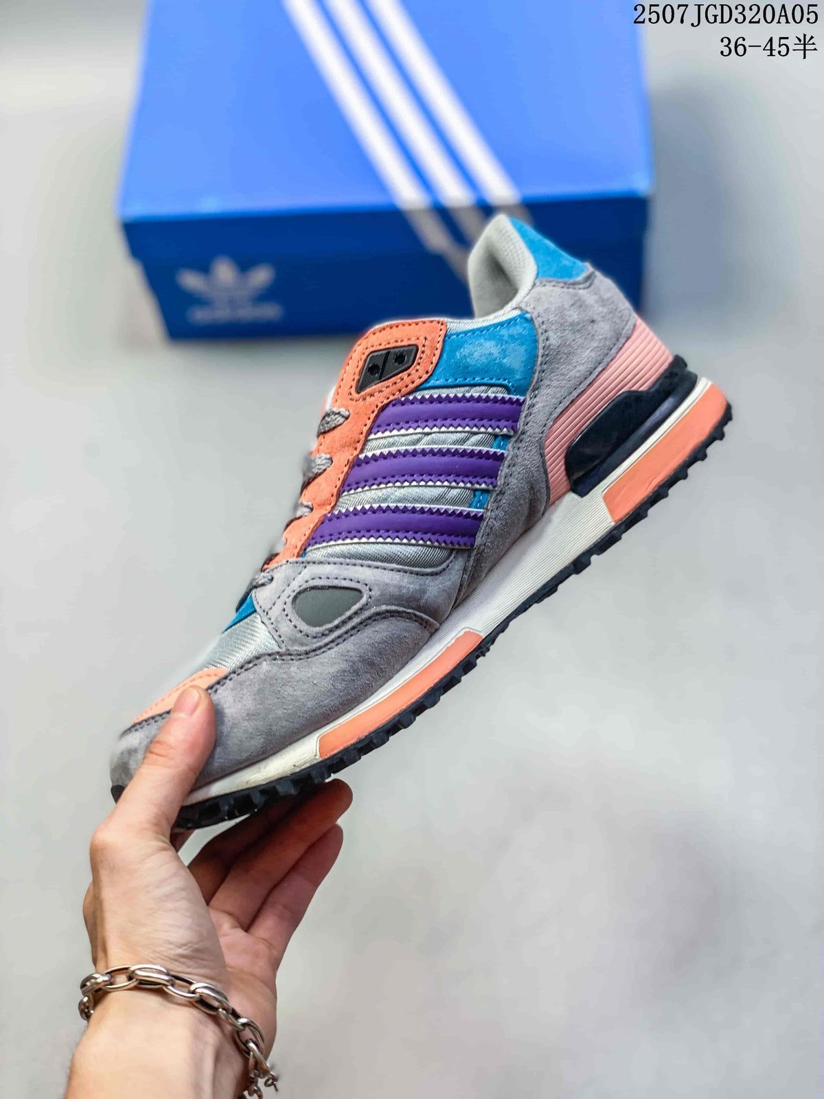 Side view of a gray adidas ZX 750 sneaker with purple stripes and coral details.