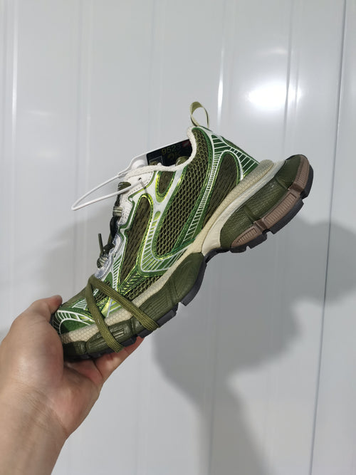 Side view of the olive green mesh sneaker showing layered overlays, dark laces, and a segmented outsole.
