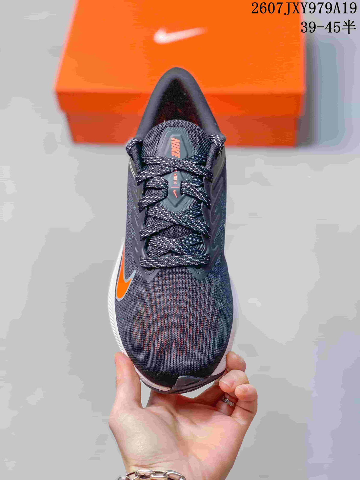 Top view of the lace-up Nike running shoe showing the dark gray upper and orange accents; image text shows style code 2607JXY979A19 and size range 39–45.