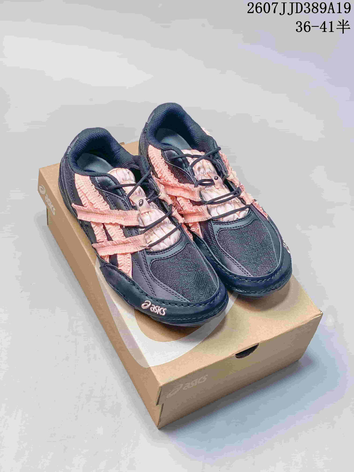 Pair of black ASICS Hypersync sneakers with pink detailing displayed on a shoebox; overlay shows 2607JJD389A19 and sizes 36–41.5.