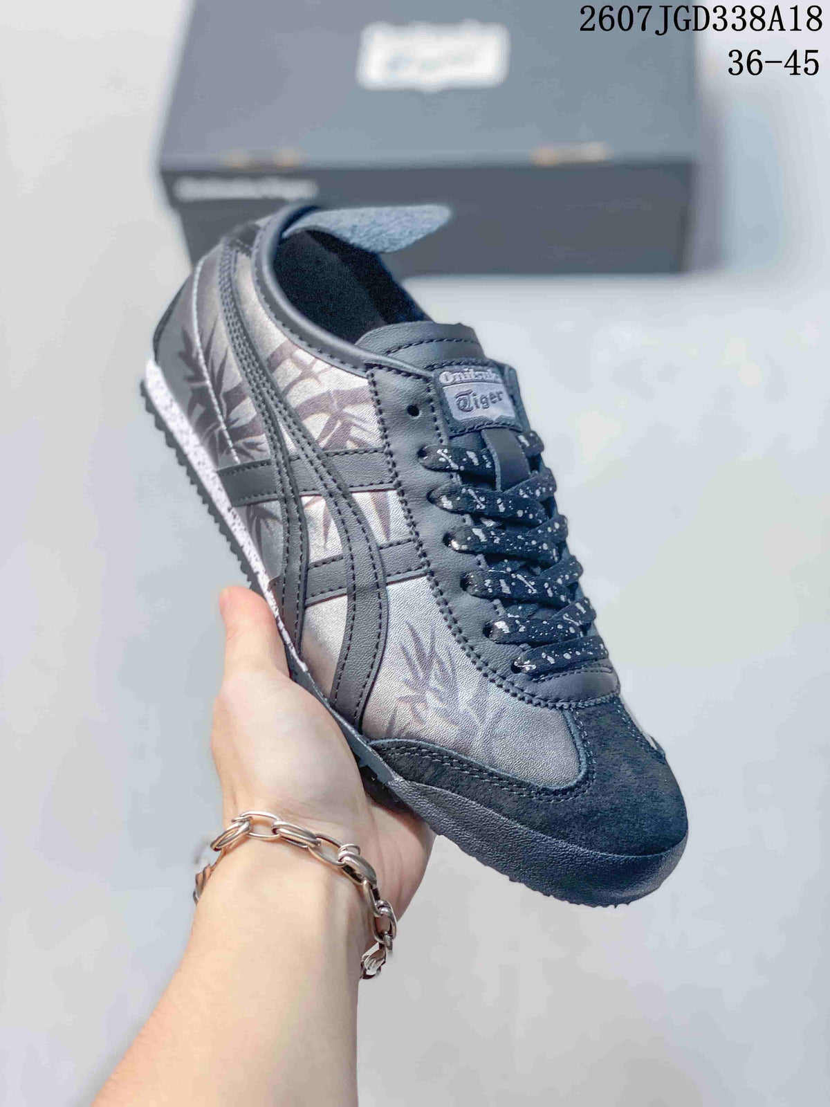Angled side view showing the gray upper, contrasting stripes, dark overlays, and rubber sole.