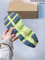 Underside view of the shoe showing a lime outsole with dark segmented traction sections and geometric tread details.