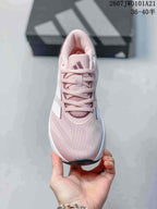 Top view of the pink lace-up sneaker showing the perforated-looking tongue area, laces and Adidas logo.
