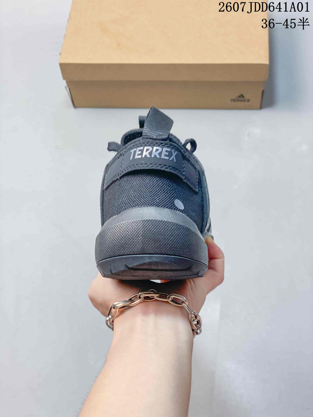 Rear view of a gray sneaker showing the heel pull tab and Terrex branding.