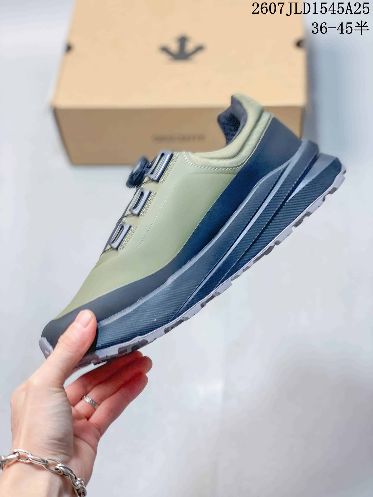 Side profile showing the olive upper, black toe and heel overlays, layered midsole, and lugged outsole.