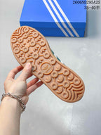 Close view of the Adidas sneaker outsole with a gum-colored circular and trefoil-patterned tread.