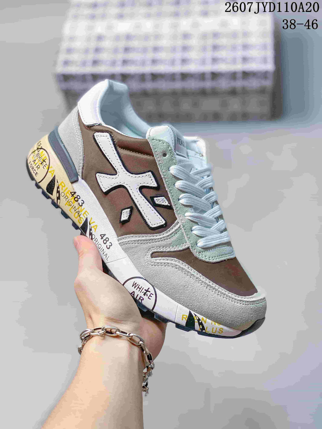 Brown, gray, and white Premiata sneaker with layered panels and a printed midsole.