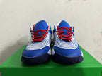 Front view of white and blue Nike basketball shoes with red laces.