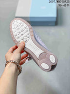 Underside view showing the textured outsole and circular traction elements of the pearl pink sneaker.