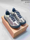 Pair of norda trail-running shoes in gray and off-white, shown from above on a box.