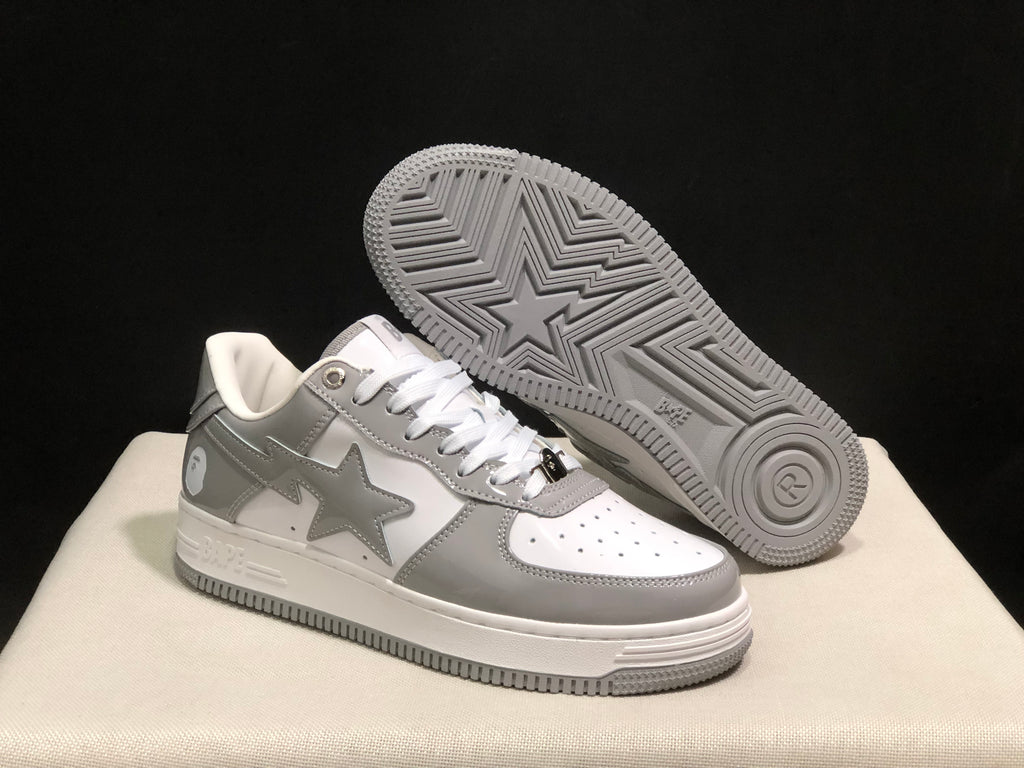 Angled view of the sneakers with one shoe lifted to show the patterned grey outsole.