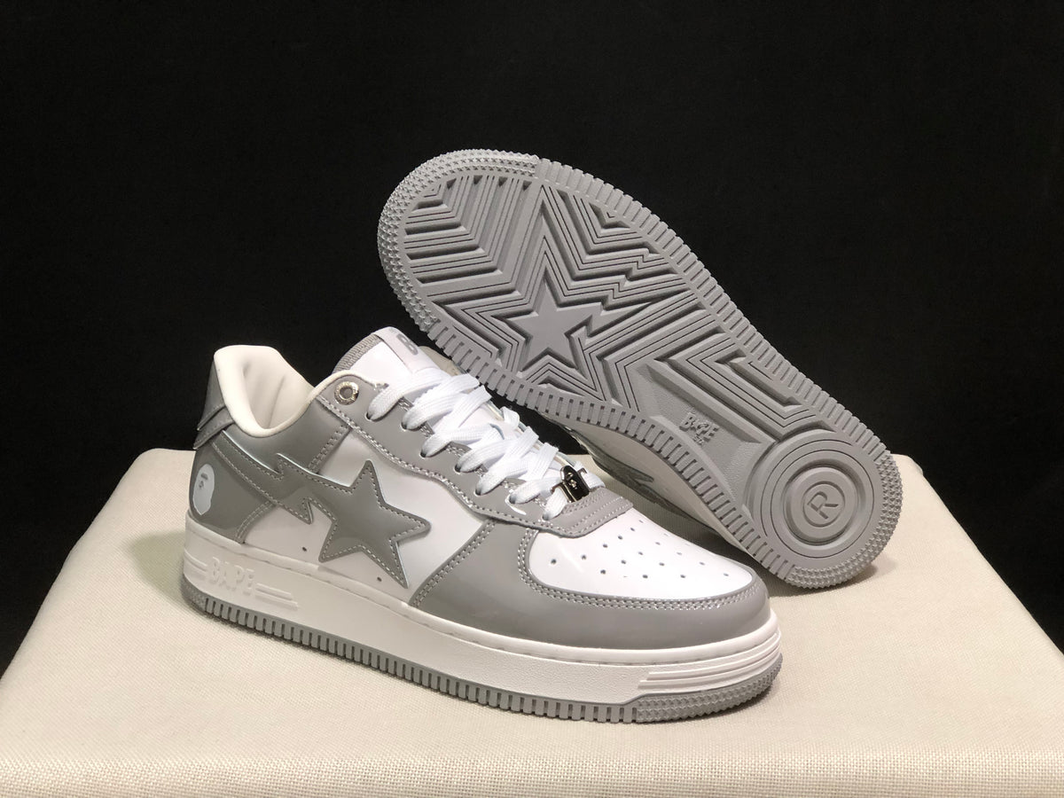Angled view of the sneakers with one shoe lifted to show the patterned grey outsole.