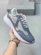 Gray and white Prada America's Cup low-top sneaker with glossy gray overlays.