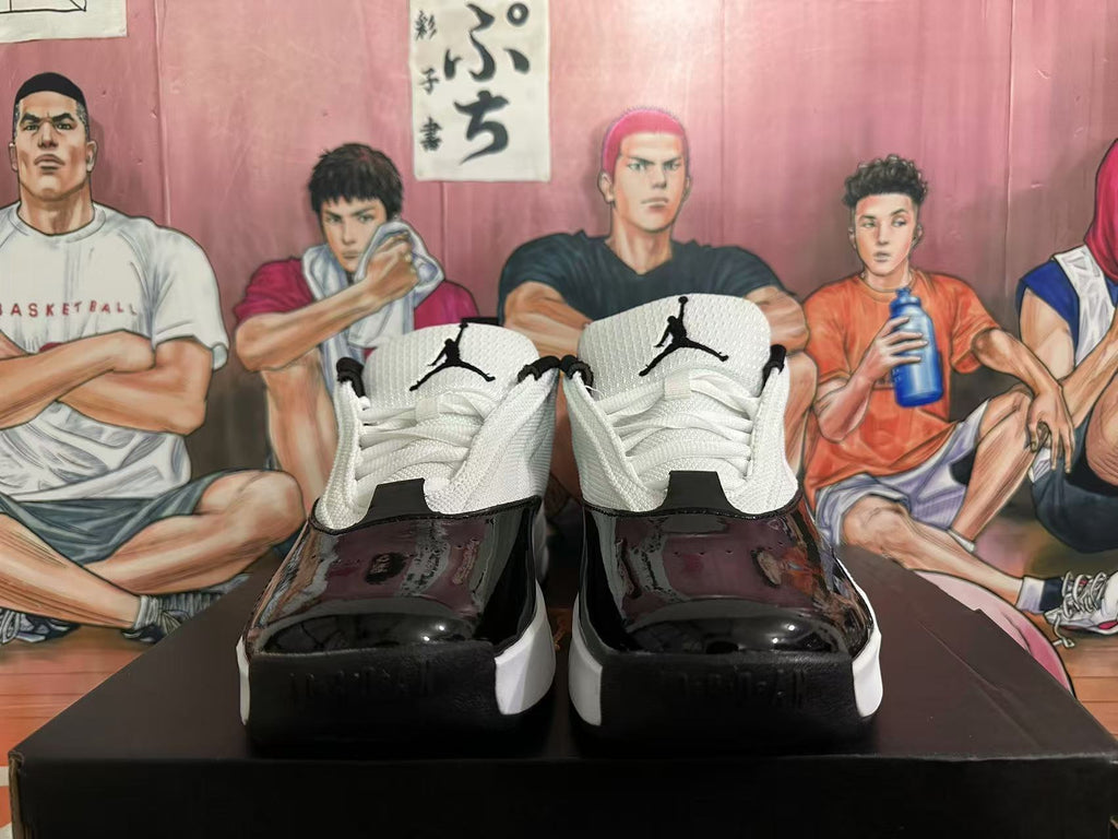 Front view of the paired sneakers showing white laces, Jumpman tongue logos, and glossy black toe panels.