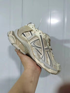 Front three-quarter view highlighting the beige and yellow layered panels, laces, padded collar, and rugged outsole of the Reebok 1205 sneaker.