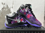 Two black and purple basketball-style sneakers displayed at an angle