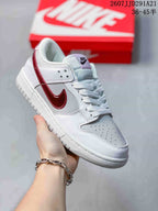 Angled side view showing the white and red colorway, lace-up construction, perforated toe box, and low-top shape.