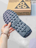Close view of the rugged black outsole with raised tread blocks and cutout details.