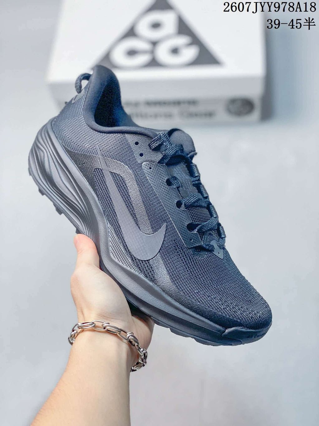 Dark gray Nike ACG Pegasus Trail sneaker with matching tonal branding and a lugged outsole.