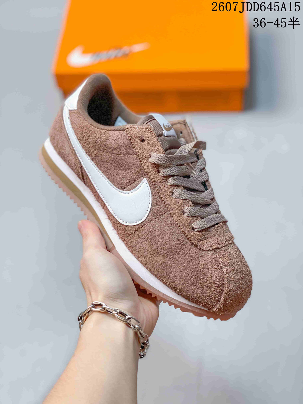 Angled side view of the brown and white Nike sneaker showing the Swoosh, low-cut collar, lace-up design, and layered sole.