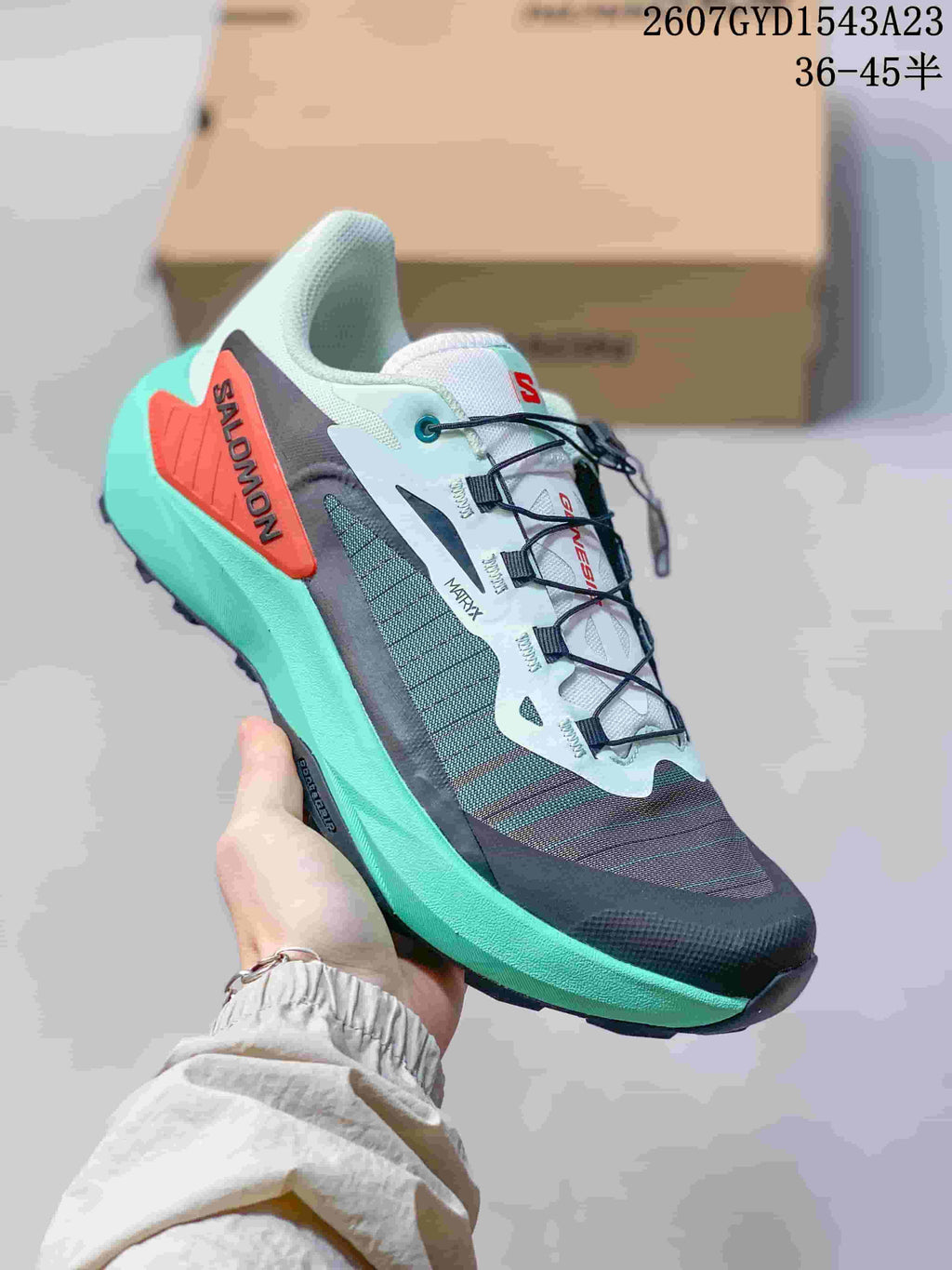 Gray, white and turquoise Salomon Genesis shoe with a red heel overlay and turquoise midsole.