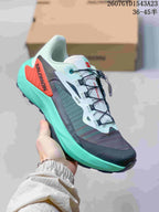 Gray, white and turquoise Salomon Genesis shoe with a red heel overlay and turquoise midsole.