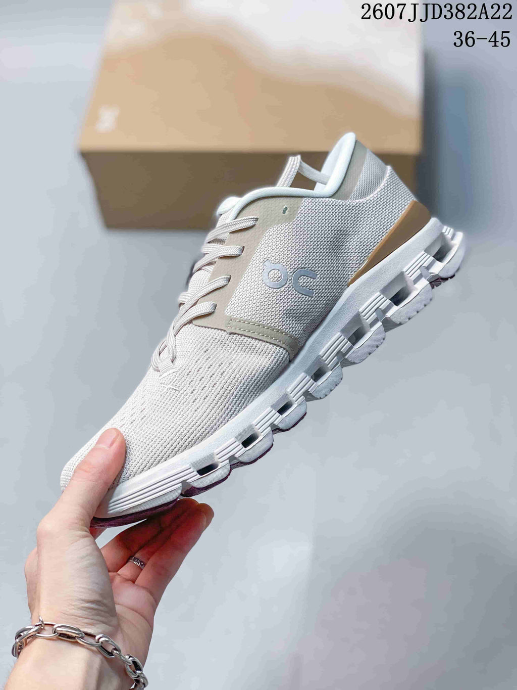 Side view of a light gray On Cloud X 4 sneaker showing the mesh-style upper, side branding, laces, and segmented outsole.