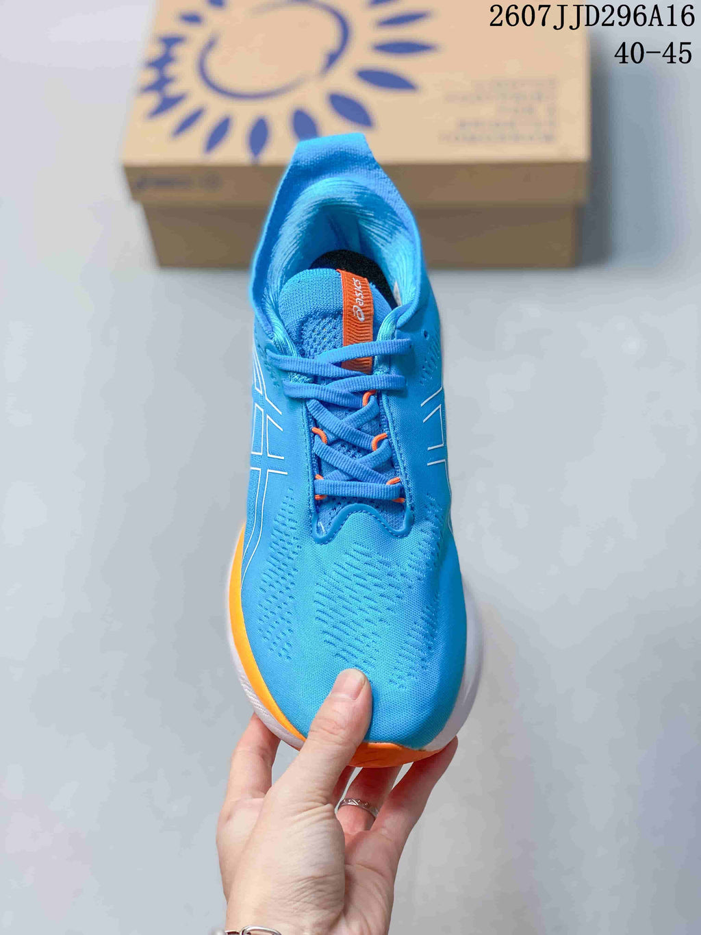 Top view of the blue lace-up running shoe showing the perforated-looking upper, orange lace details, and padded tongue.