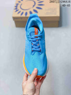 Top view of the blue lace-up running shoe showing the perforated-looking upper, orange lace details, and padded tongue.