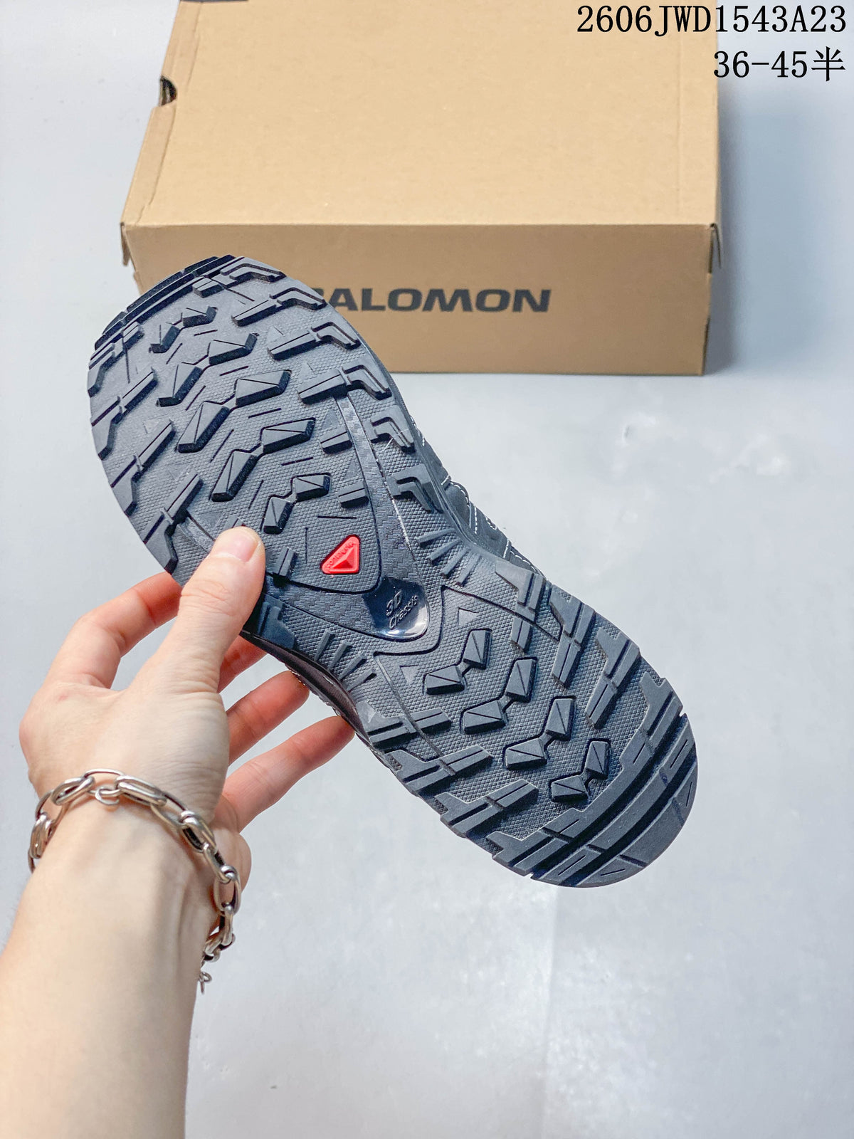 Close-up of the deeply treaded outsole on a dark Salomon shoe; image overlay lists sizes 36–45.5.