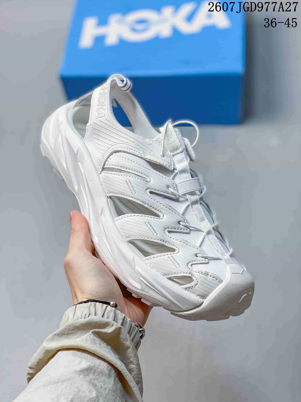 Angled view of the white HOKA Hopara OG sandal with heel strap, cord lacing and textured outsole.