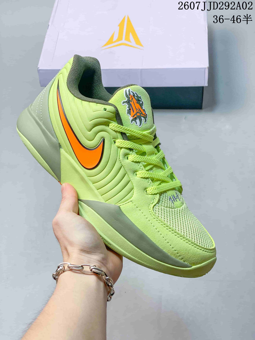 Light green Nike JA 2 basketball shoe with an orange Swoosh and matching laces.