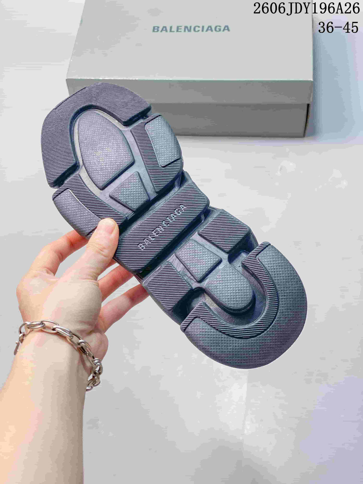 Underside view of a dark gray sneaker showing the segmented textured outsole and Balenciaga branding.