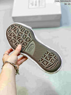 Close view of the dark patterned outsole and sculpted white midsole of an MMY sneaker; image text shows style code 2506JXD320A29 and size range 36–45.