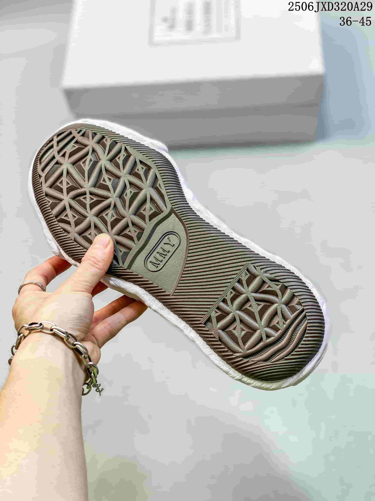 Close view of the dark patterned outsole and sculpted white midsole of an MMY sneaker; image text shows style code 2506JXD320A29 and size range 36–45.