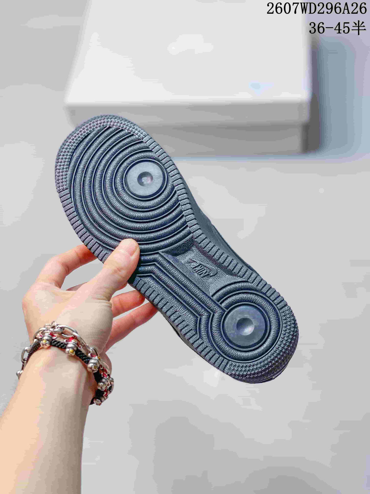 Black sneaker outsole held in hand, showing concentric circular tread patterns and textured edges.