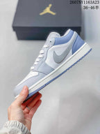 Side profile showing the light grey and white low-top sneaker, textured side panel, and patterned outsole.