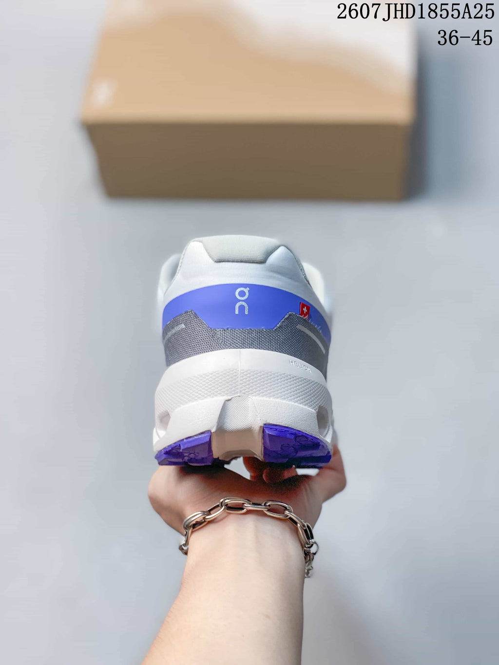 Rear view of the white and blue sneaker showing the padded heel collar, blue heel panel, and segmented outsole.