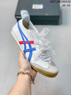 Angled side view of the white sneaker with blue and red stripes and a gum-colored sole.