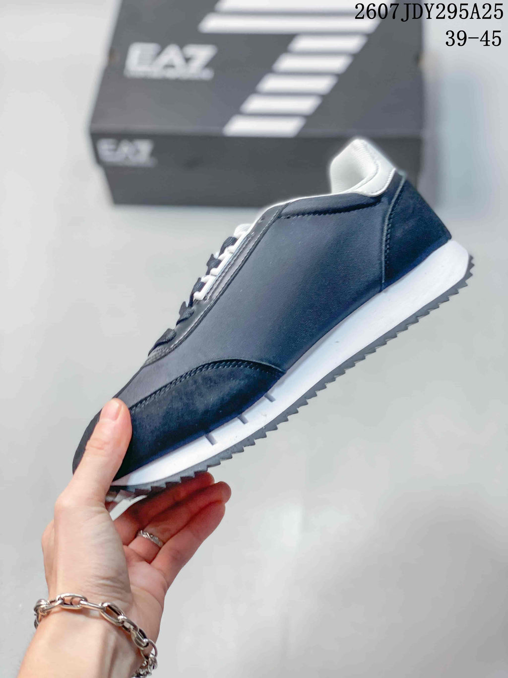 Side profile of the navy low-top sneaker showing the layered upper, white midsole, and serrated dark outsole edge.